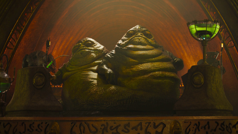 Two Hutts looking down on people from a throne in The Mandalorian and Grogu
