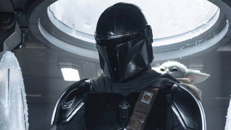 Din Djarin and Grogu standing in their spaceship in The Mandalorian and Grogu