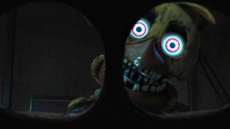 Withered Chica looking into a mask in Five Nights at Freddy's 2