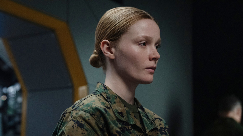 Ines Asserson as A.J. Jarrett looking somber as she receives orders in a military uniform in For All Mankind