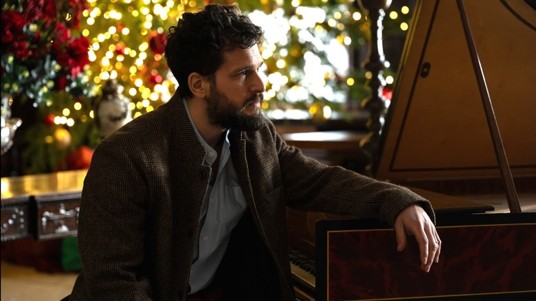 Henry assis à un piano devant un sapin de Noël sur Industry
