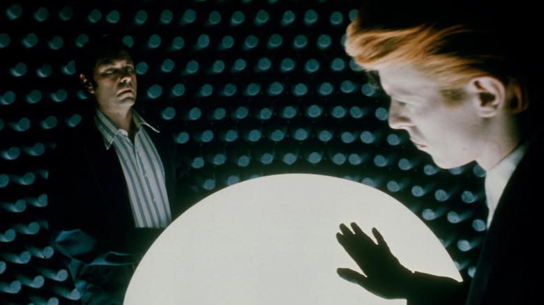 Thomas Jerome Newton stroking a large glowing orb in front of Dr. Bryce in The Man Who Fell to Earth