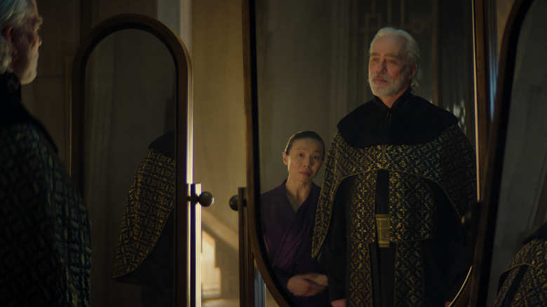 Terrence Mann as Brother Dusk standing in front of a mirror staring at his reflection next to Angela Yeoh as Landell in Foundation season 3