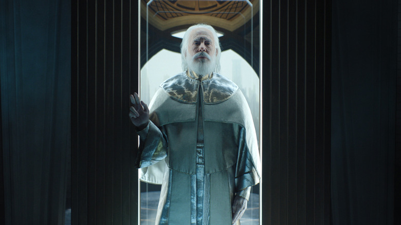 Brother Dusk with white hair and a beard standing in a doorway in Foundation season 3