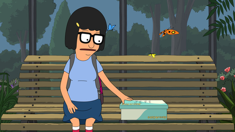 Tina sitting on a park bench with a shoe box labeled Jeff on Bob's Burgers