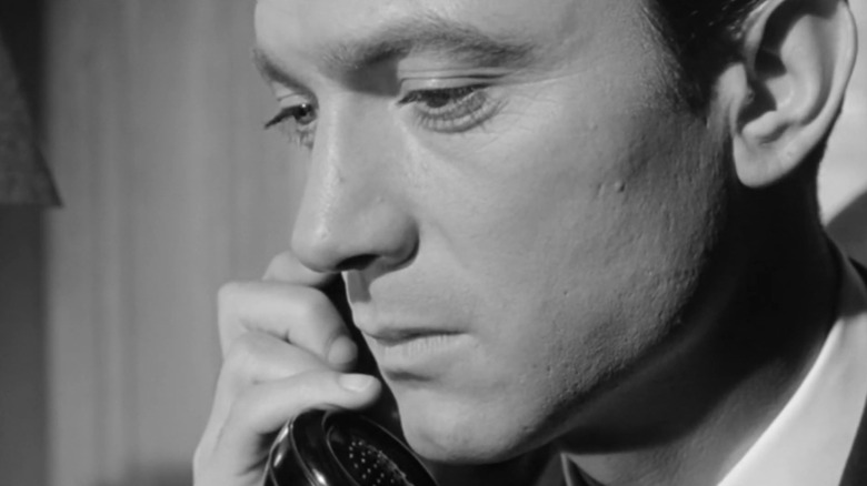 Laurence Harvey's Raymond Shaw is seen in closeup as he holds a phone to his ear in The Manchurian Candidate