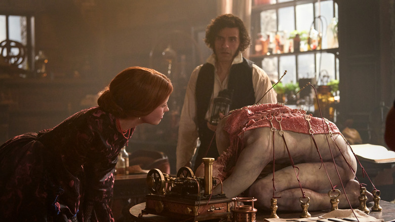 Elizabeth looks at a dissected corpse as Victor watches her in Frankenstein