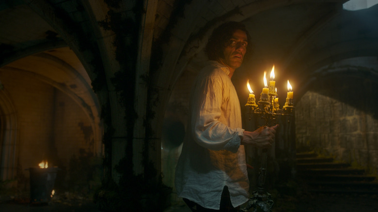 Victor holds a candelabra in Frankenstein
