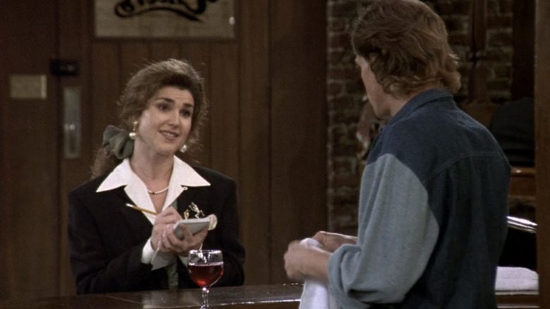 Reporter Holly Matheson stands in Cheers bar talking Woody across the bar in Cheers