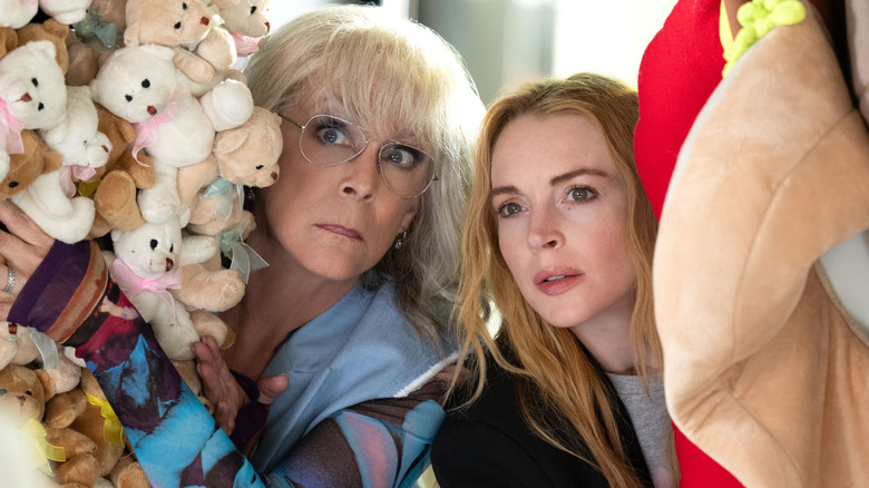 Tess (Jamie Lee Curtis) and Anna (Lindsay Lohan) peeking out from behind some toy animals in Freakier Friday