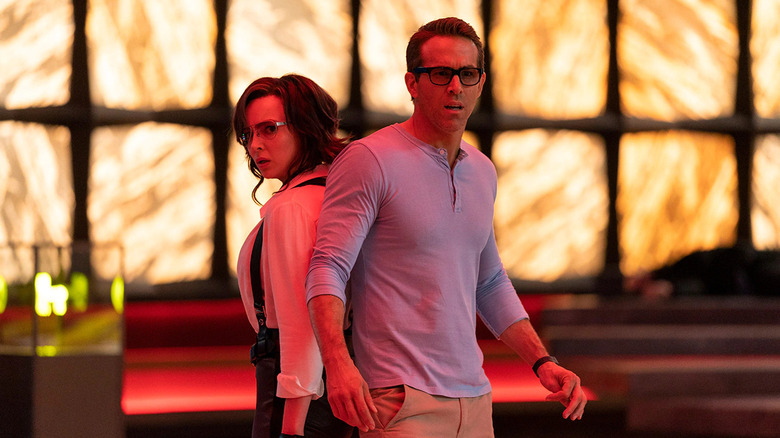 Jodie Comier and Ryan Reynolds stand back to back