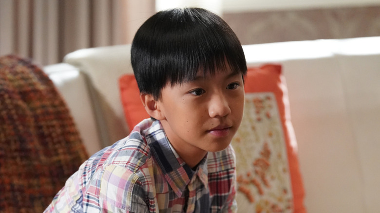 Ian Chen as Evan Huang sits on a couch in Fresh Off the Boat
