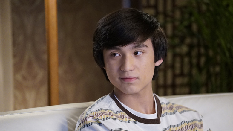 Forrest Wheeler as Emery Huang sitting on a couch in Fresh Off the Boat.
