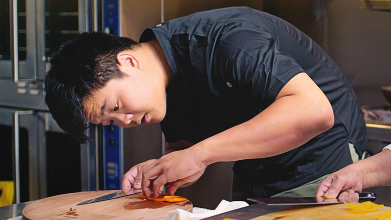 Hudson Yang cooks in a kitchen in Crash Course Cuisine with Hudson Yang.
