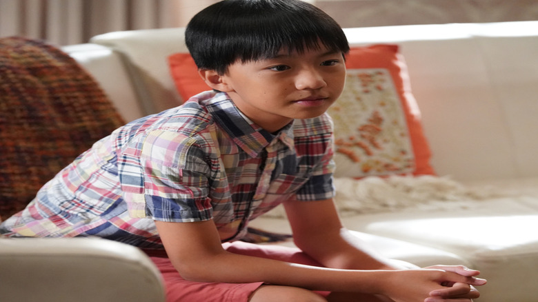 Ian Chen as Evan Huang sits on a couch in Fresh Off the Boat
