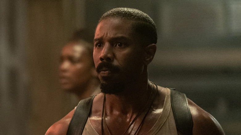 Michael B. Jordan as Smoke, looking scared in a barn in Sinners