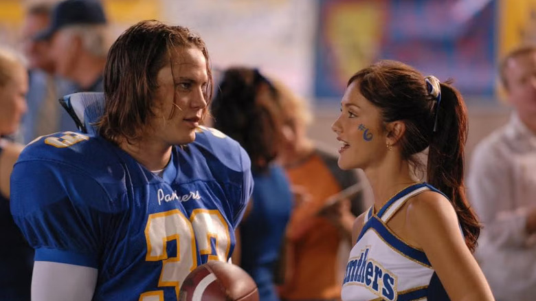 Riggins (Taylor Kitsch) and Lyla (Minka Kelly) talking on the field in Friday Night Lights