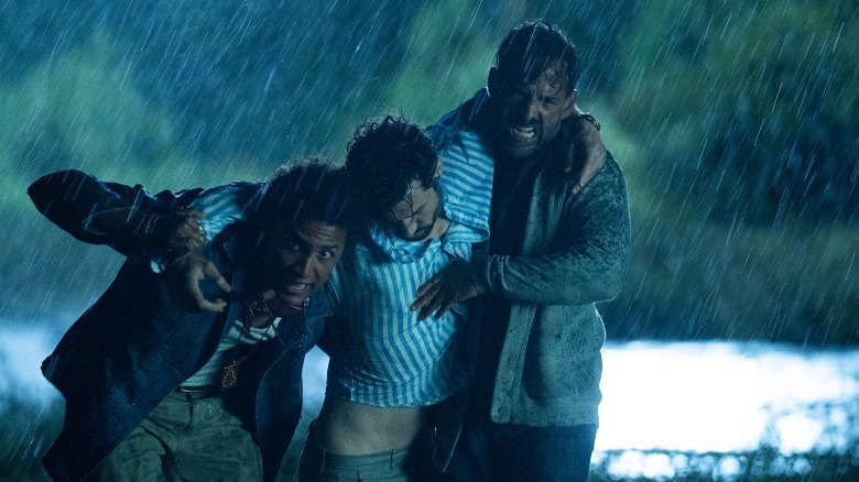 Men carry unconscious guy, raining