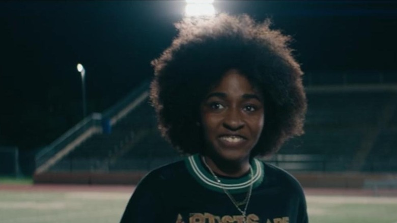 Ayo Edebiri as Josie  standing on a football field in Bottoms
