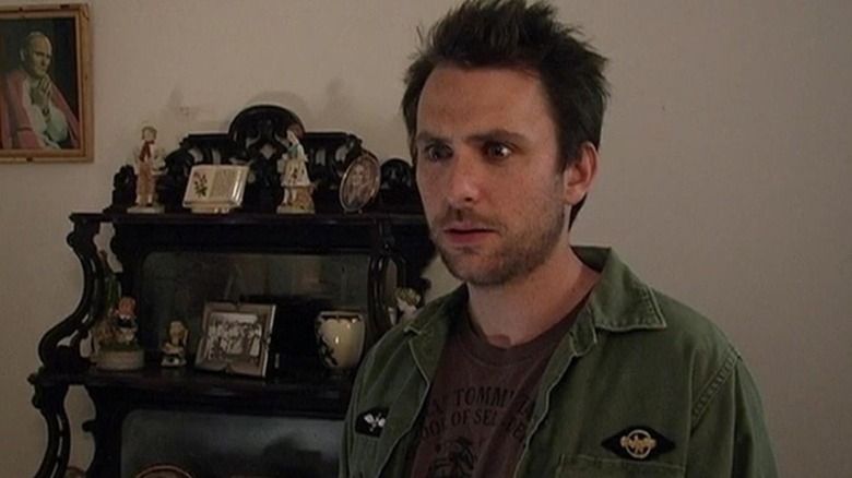 Charlie Day as Charlie on It's Always Sunny in Philadelphia, looking very upset in front of a bunch of tchotchkes