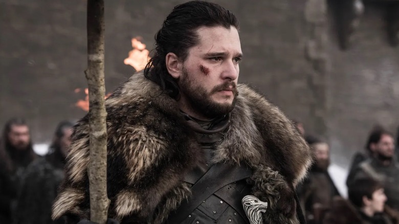 Jon Snow holding a torch with a cut cheek in Game of Thrones