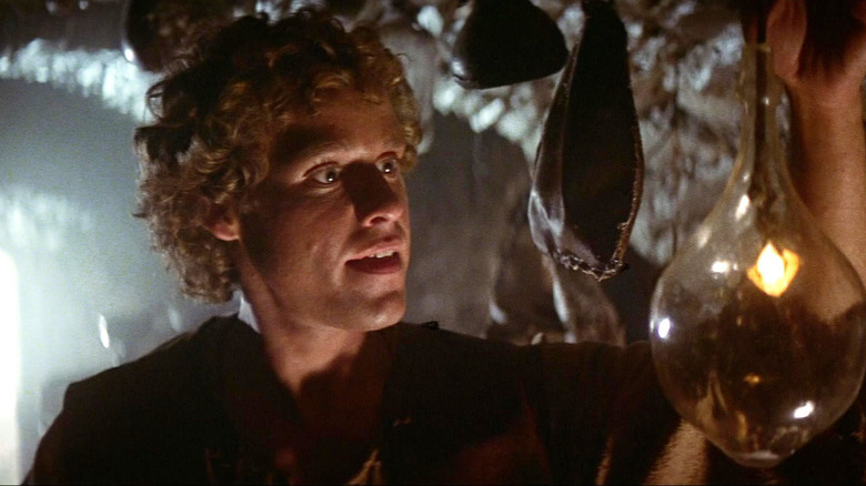 Peter MacNicol as Galen Bradwarden looking at a hanging glass orb in Dragonslayer