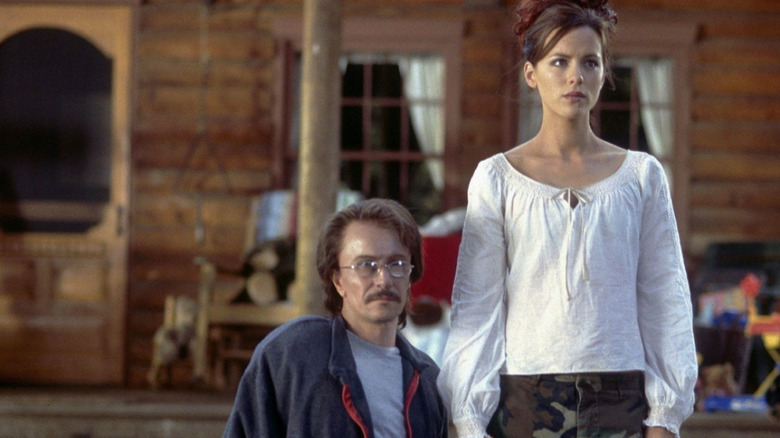 Rolf and Carol hold their hands in front of a house in the fingertips of the accusation