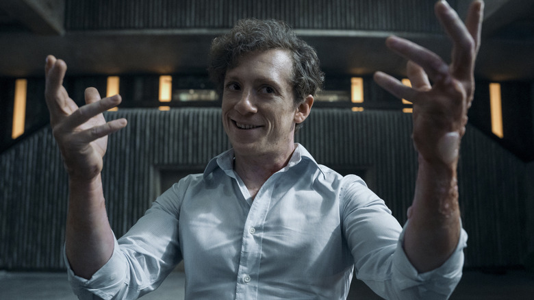 Ethan Slater as Thomas Godolkin smirking and holding up his arms in a threatening pose in Gen V