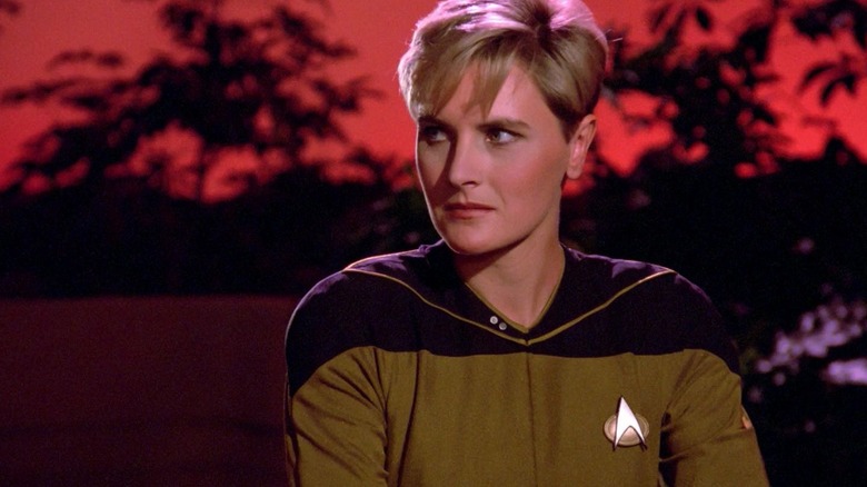 Tasha Yar em um planeta exótico com céu vermelho em Star Trek: The Next Generation