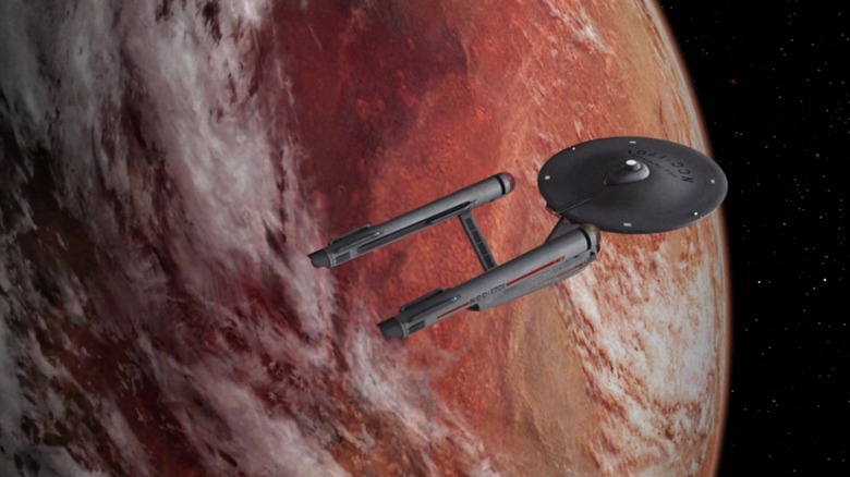 The U.S.S. Enterprise flying over a planet in Star Trek: The Original Series