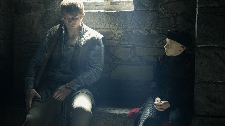Peter Claffey as Ser Duncan the Tall sitting on a stone bench next to Dexter Sol Ansell as Egg in A Knight of the Seven Kingdoms