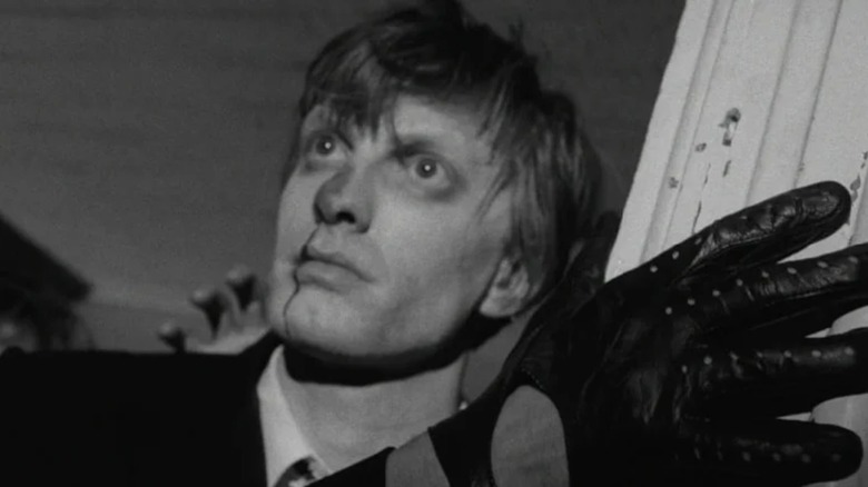 A reanimated ghoul stumbling into the house in Night of the Living Dead