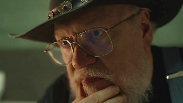 జార్జ్ RR మార్టిన్ డార్క్ విండ్స్‌లో చెస్ ఆడుతున్న జార్జ్‌గా