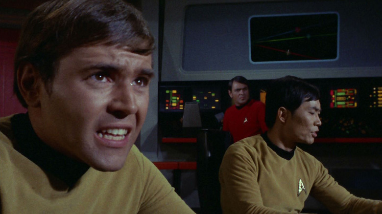 Walter Koenig as Pavel Chekov sitting at his console next to George Takei as Hikaru Sulu in Star Trek: The Original Series