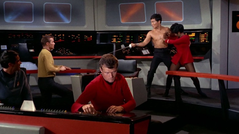 Sulu holding Uhura and threatening Kirk with a fencing foil in Star Trek