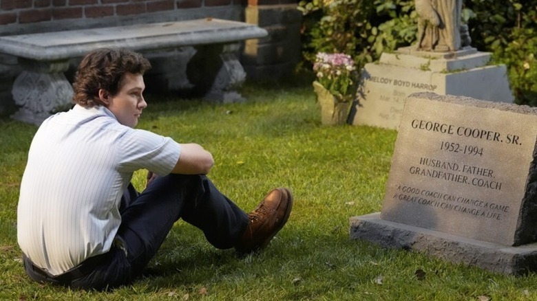 George sitting next to his father's grave on the first marriage of George and Mandy