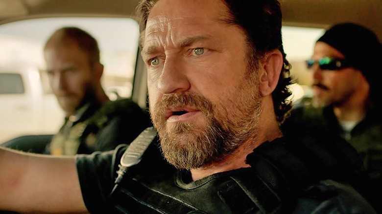 Gerard Butler driving a police car as Big Nick O'Brien in Den of Thieves
