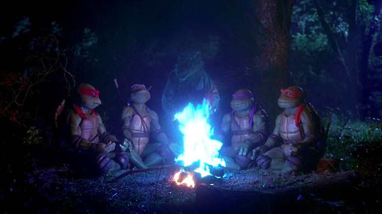 Josh Pais, Leif Tilden, David Forman, and Michelan Sisti sit around a campfire as Raphael, Leonardo, Donatello, and Michelangelo in Teenage Mutant Ninja Turtles