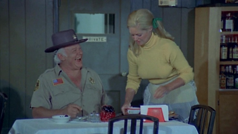 Sherrif Jones seated in a resaturant being served by a waitress in The Giant Spider Invasion