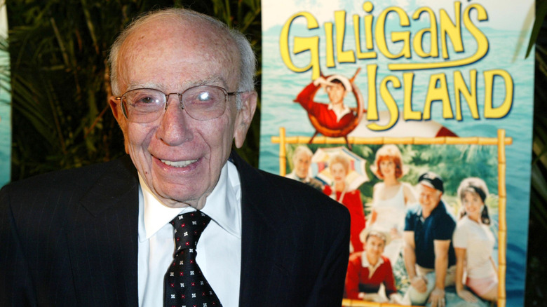 Sherwood Schwartz with the Gilligan's Island poster behind him