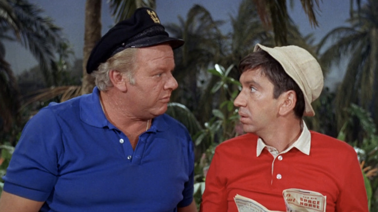 అలాన్ హేల్ జూనియర్ యొక్క స్కిప్పర్ గిల్లిగాన్స్ ద్వీపంలో బాబ్ డెన్వర్ యొక్క గిల్లిగాన్ పక్కన నిలబడి ఉన్నాడు