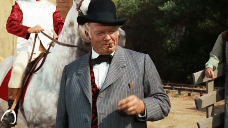 Alan Hale Jr's Dave Chaney stands next to a horse in the street in Gunsmoke