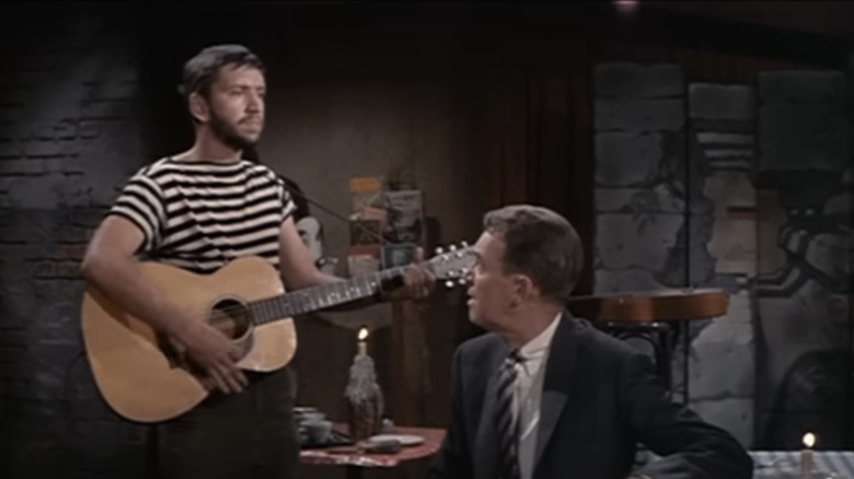 Bob Denver's coffeehouse singer plays a song while James Stewart's Frank Michaelson watches in Take Her, She's Mine