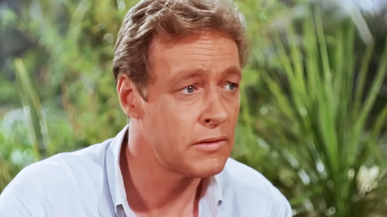 Russell Johnson's Professor Roy Hinkley is seen against a background of shrubbery in Gilligan's Island