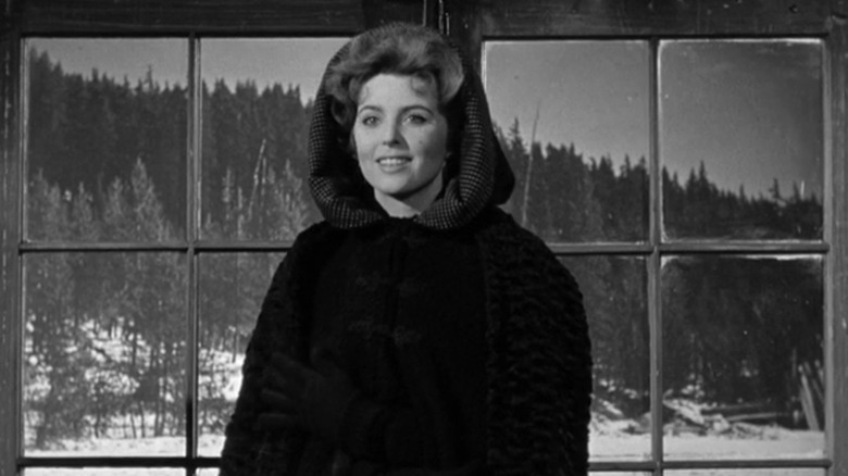 Tina Louise's Helen Crane stands in front of double doors in Day of the Outlaw