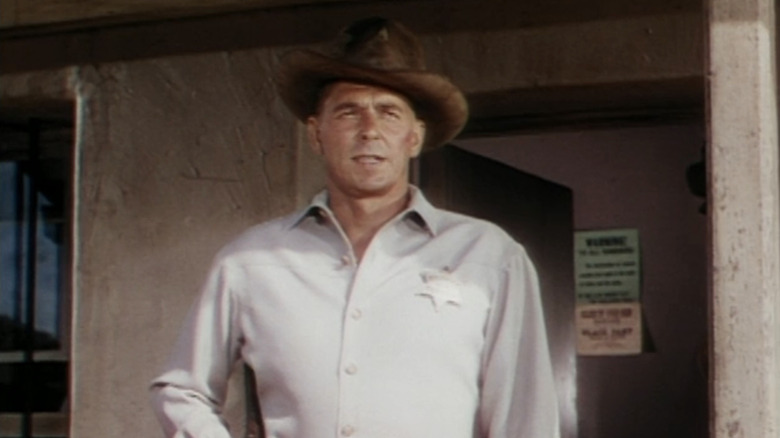 రోనాల్డ్ రీగన్ యొక్క ఫ్రేమ్ జాన్సన్ లా అండ్ ఆర్డర్‌లోని జైలు వెలుపల నిలబడి ఉన్నాడు