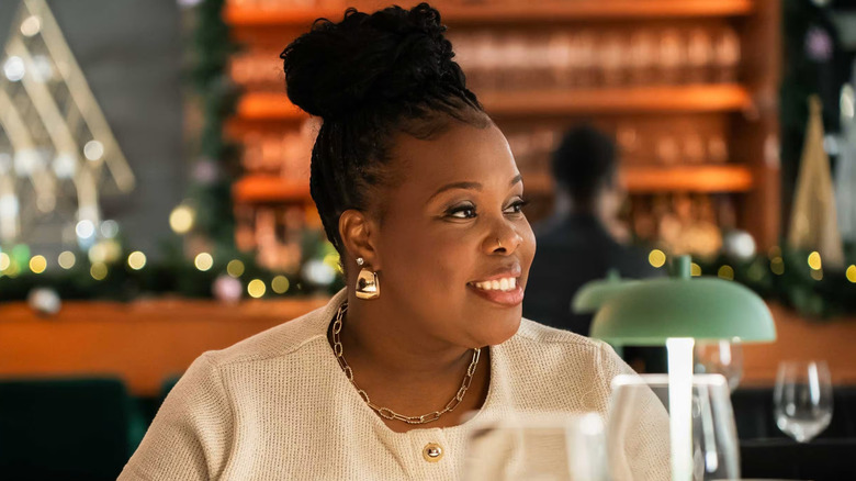 Amber Riley as Savannah Sheldon, smiling at dinner in "Savvy Sheldon"