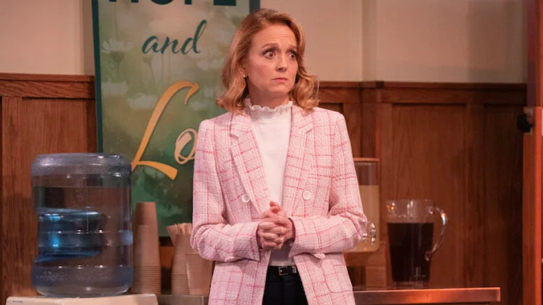Jayma Mays as Mary, standing in front of refreshments in Leanne