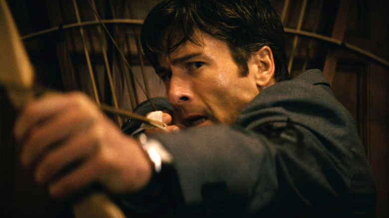 Becket Redfellow aims a bow and arrow in How to Make a Killing