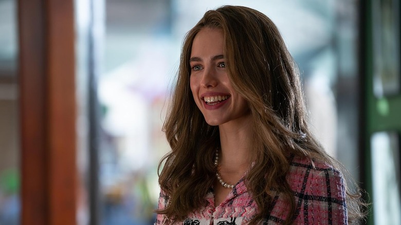 Margaret Qualley as Julia Steinway grinning wildly in How to Make a Killing